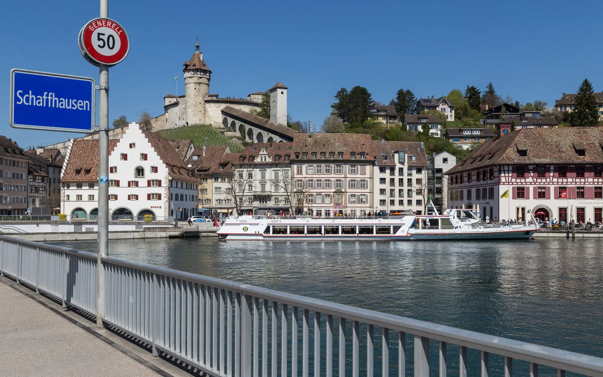 The Munot fortress above the old town of Schaffhausen, with a passenger boat moored on the Rhine