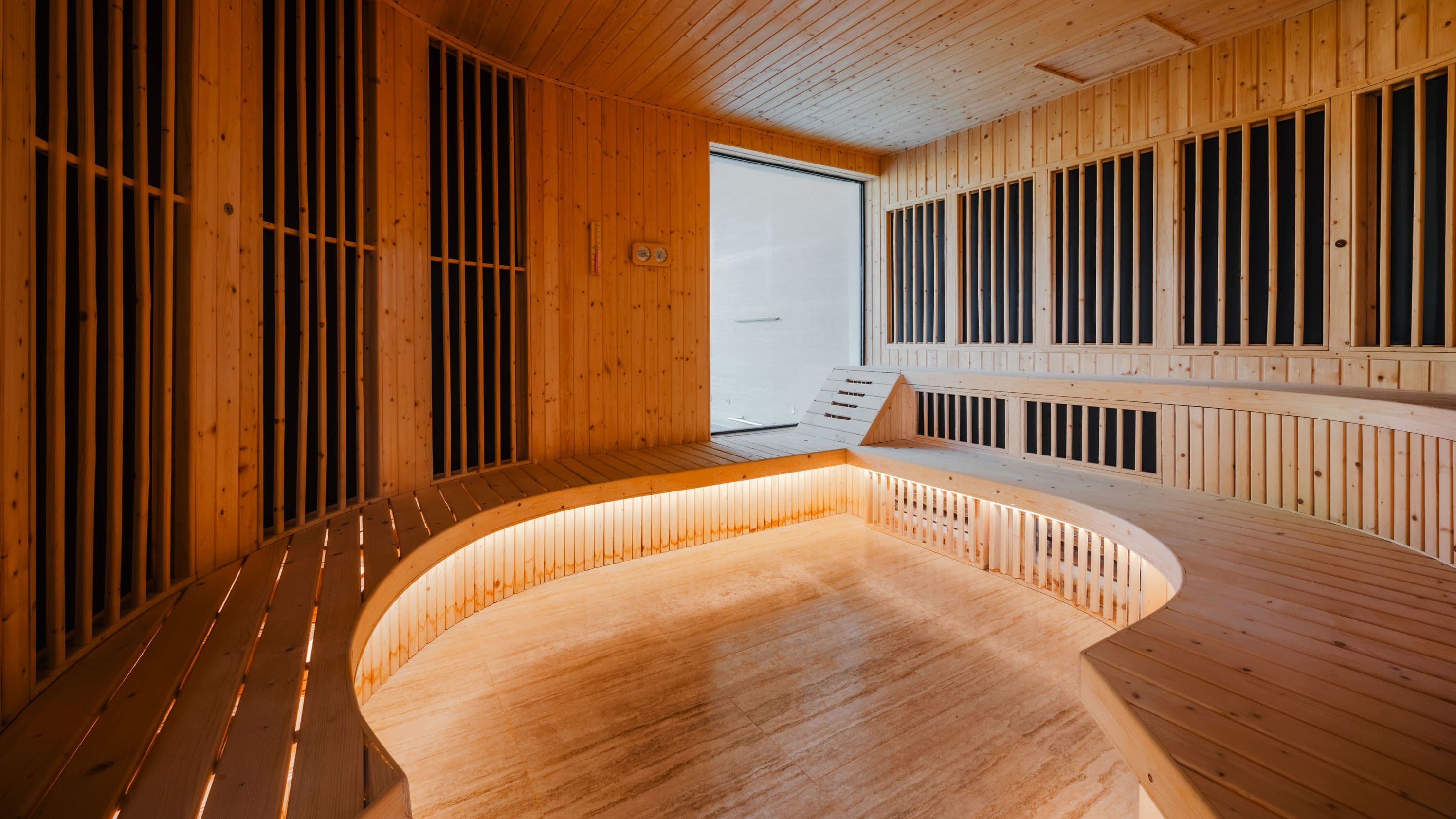 Luxury hotel sauna with curved wooden benches