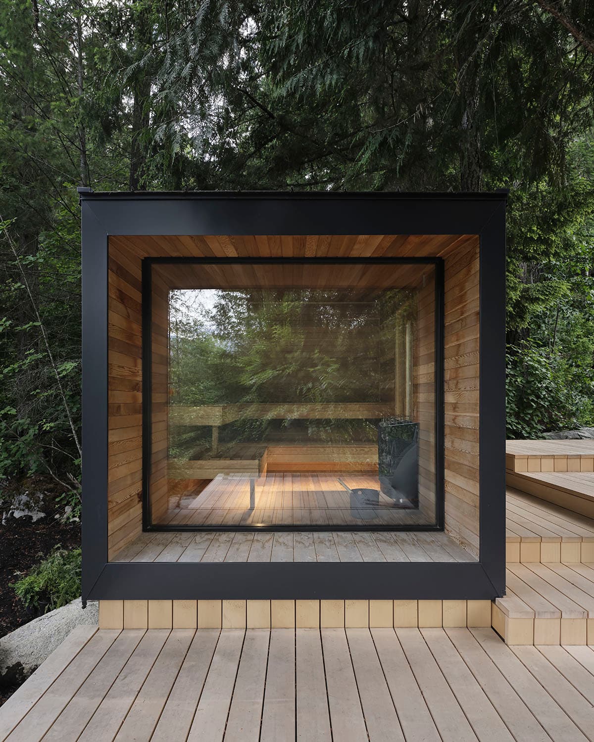 Modern modular outdoor sauna cabin with black exterior and glass window