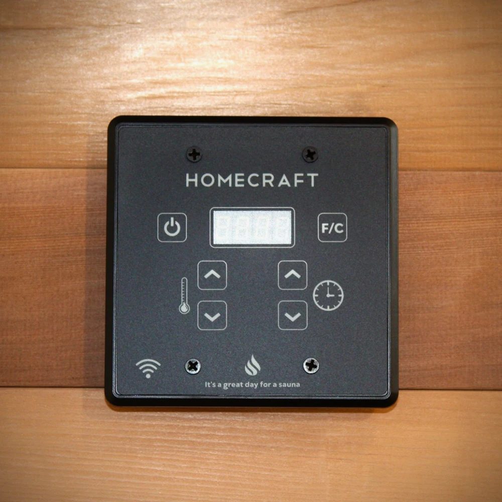 A black Homecraft WiFi touchpad with a digital display and arrow buttons on a wood sauna wall