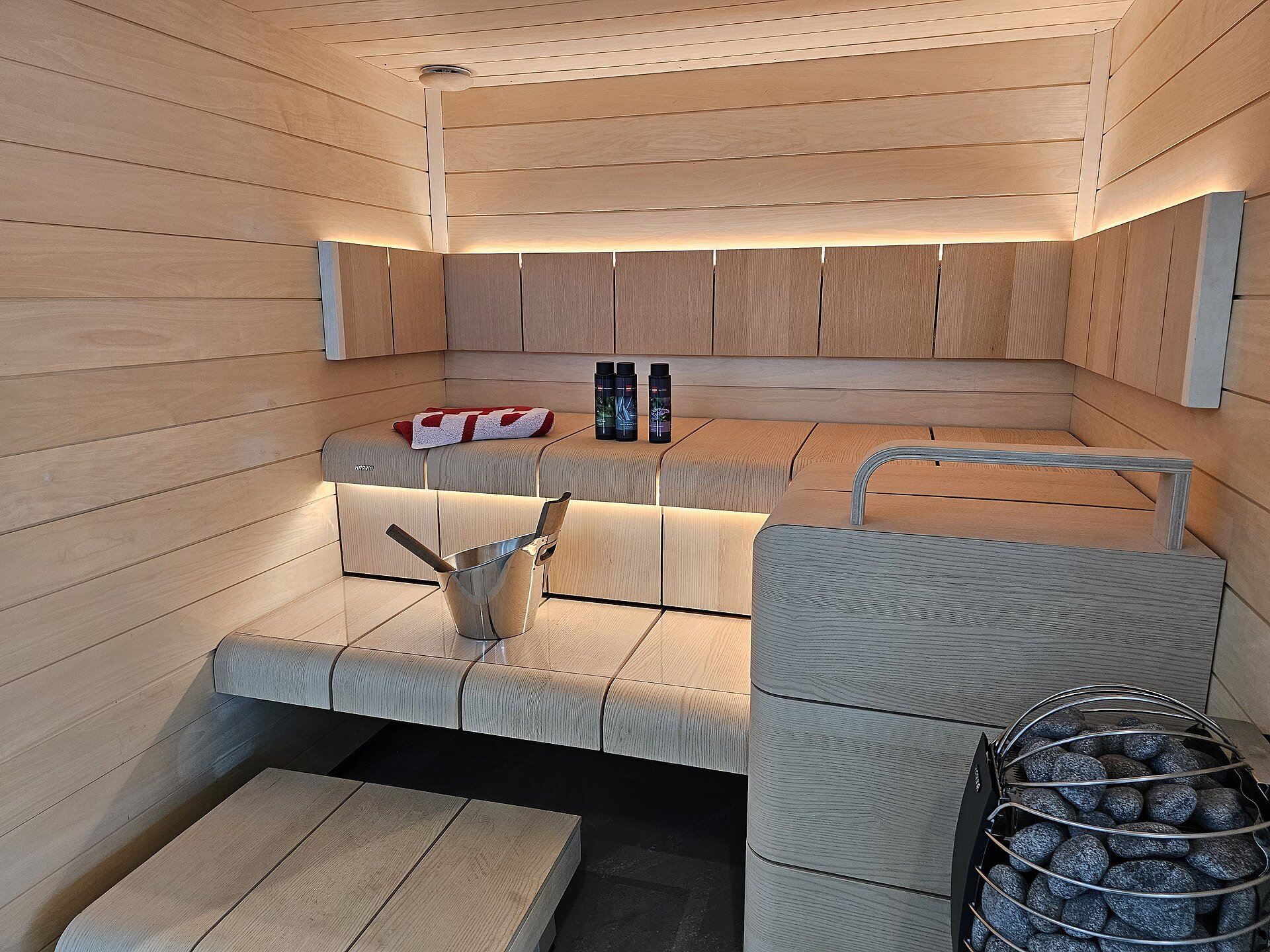 Modern sauna interior with LED-lit benches and an electric heater