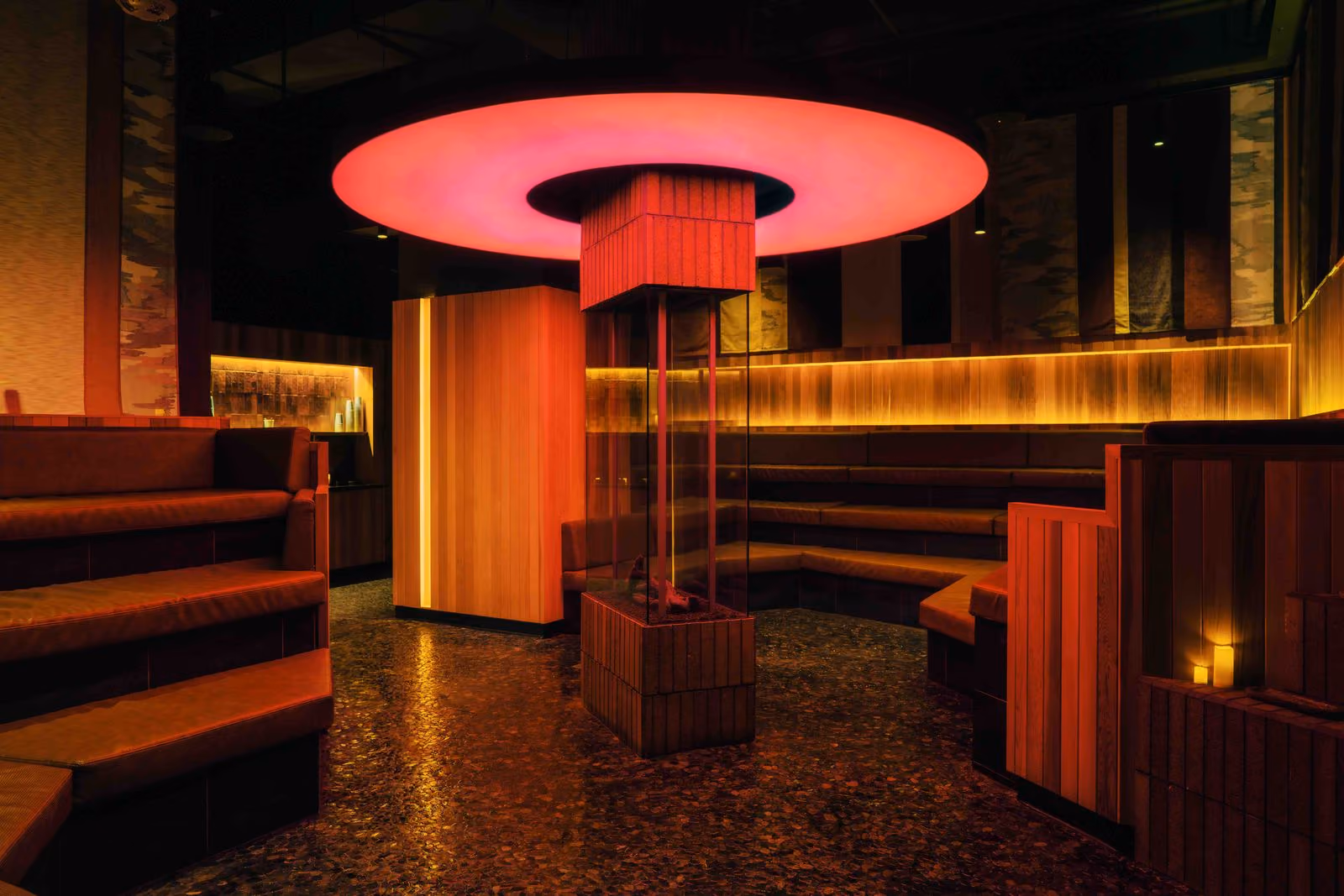 A glowing circular light above the tiered lounge at Othership Flatiron.