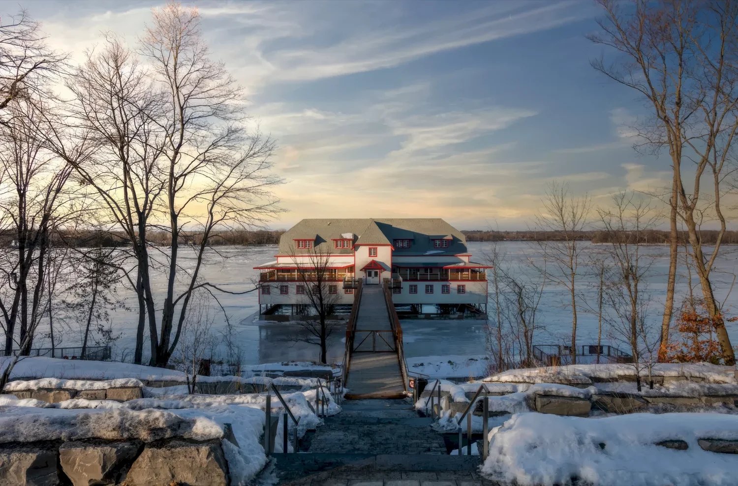 The NCC River House beside the frozen Ottawa River, seen from its shore access path
